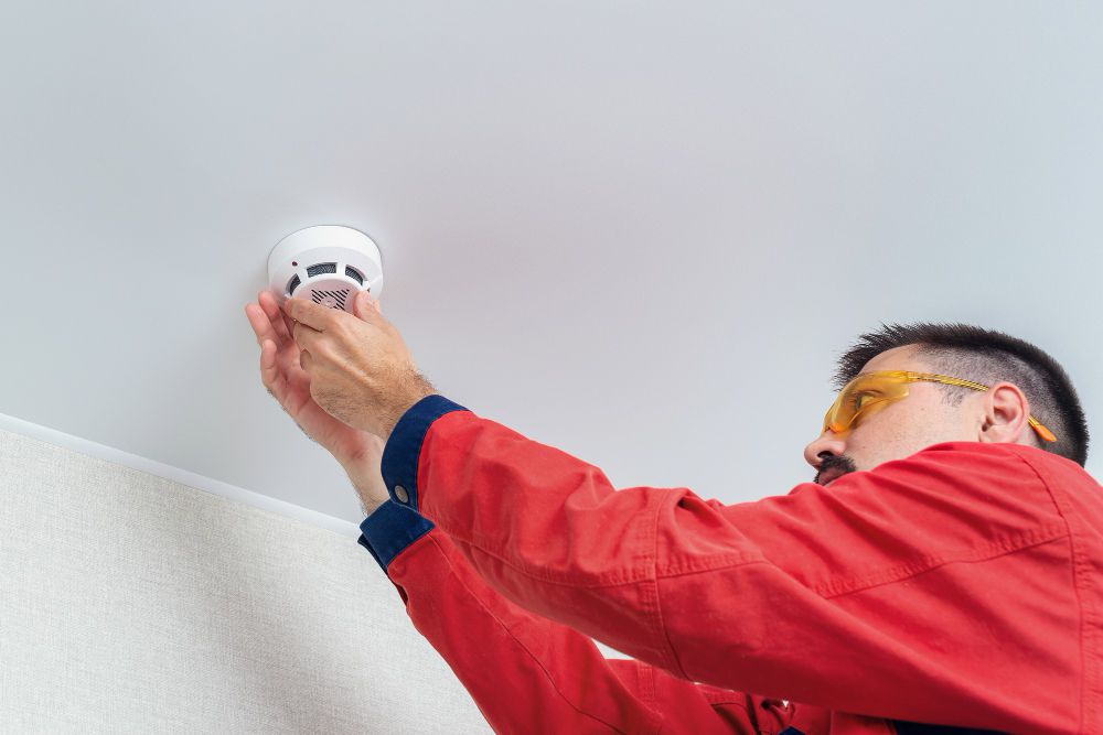 worker-installing-smoke-detector-ceiling